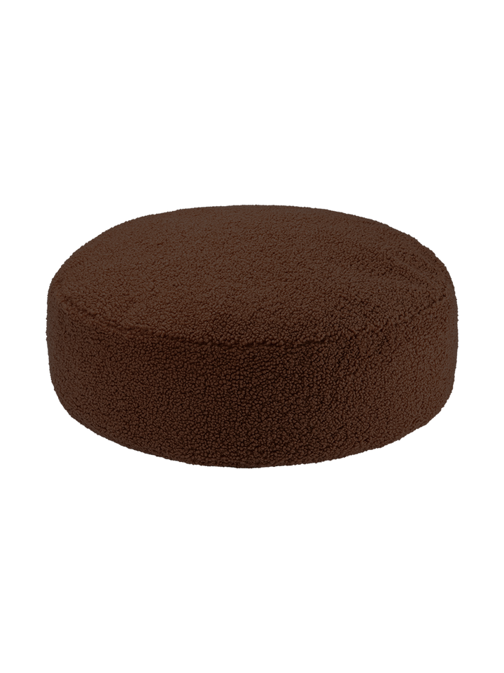 Dark brown round ottoman at angle on white background