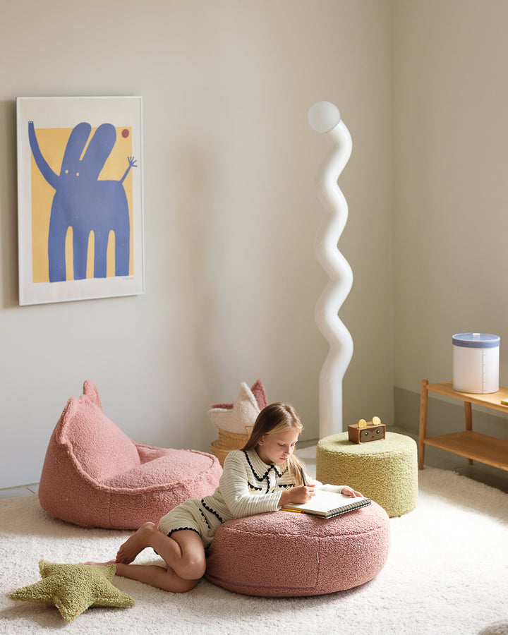 Blush pink bear-shaped beanbag and round ottoman in minimal contemporary living space