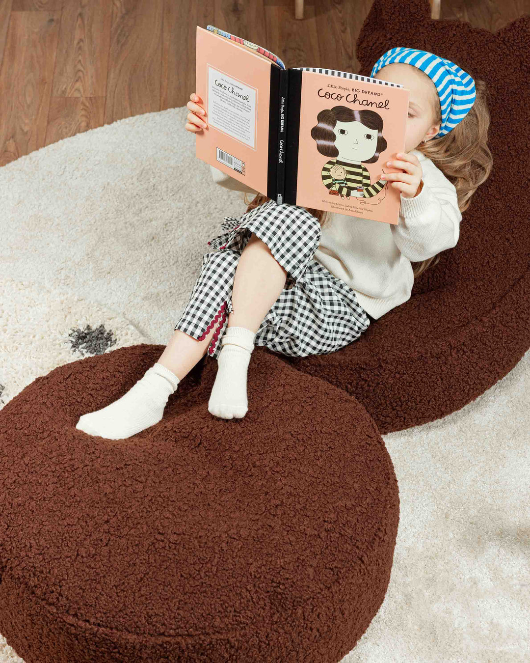 Aerial view of child on brown Wigiwama bear chair with cream ottoman in styled playroom