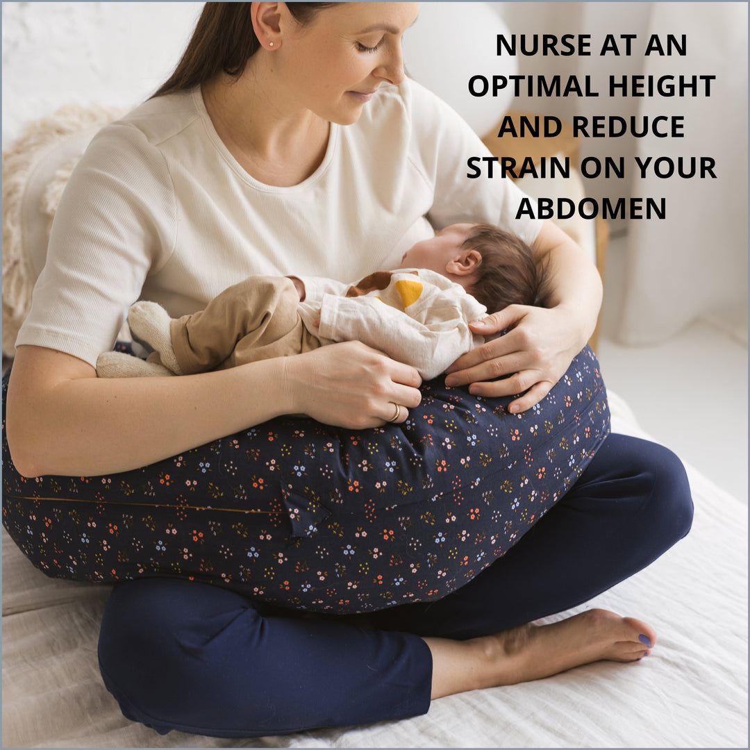 Woman nursing her baby at a comfortable height using the MINICAMP Navy Blue floral C-Shape Pillow
