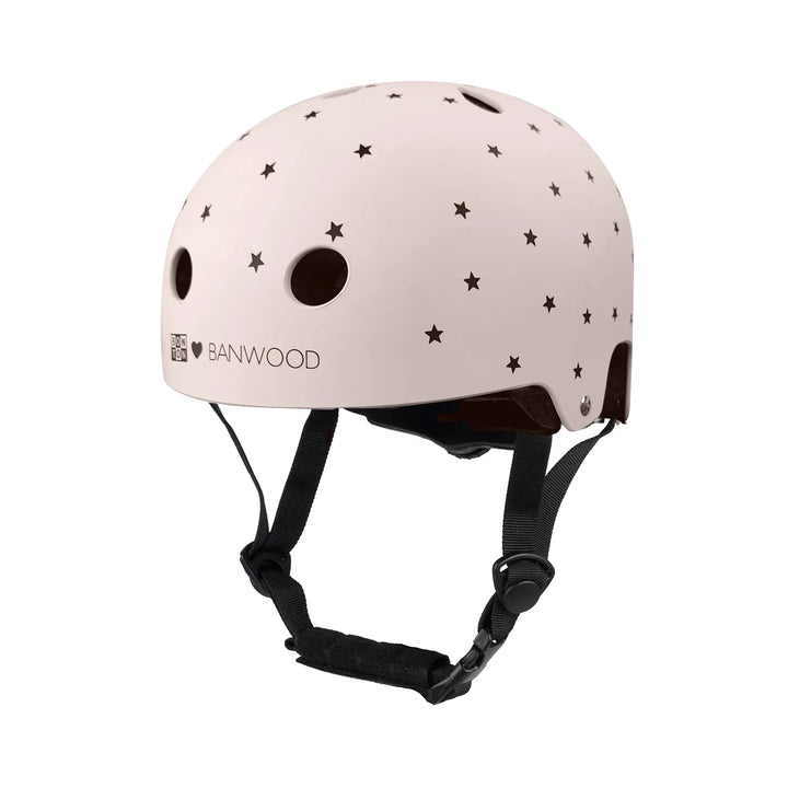 Matte pink Banwood helmet with black stars and ventilation holes, worn with black chin straps