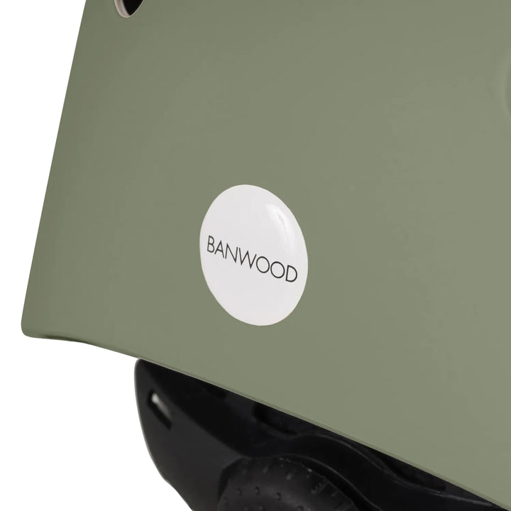 Banwood helmet rear panel detail showing white circular logo badge on sage shell