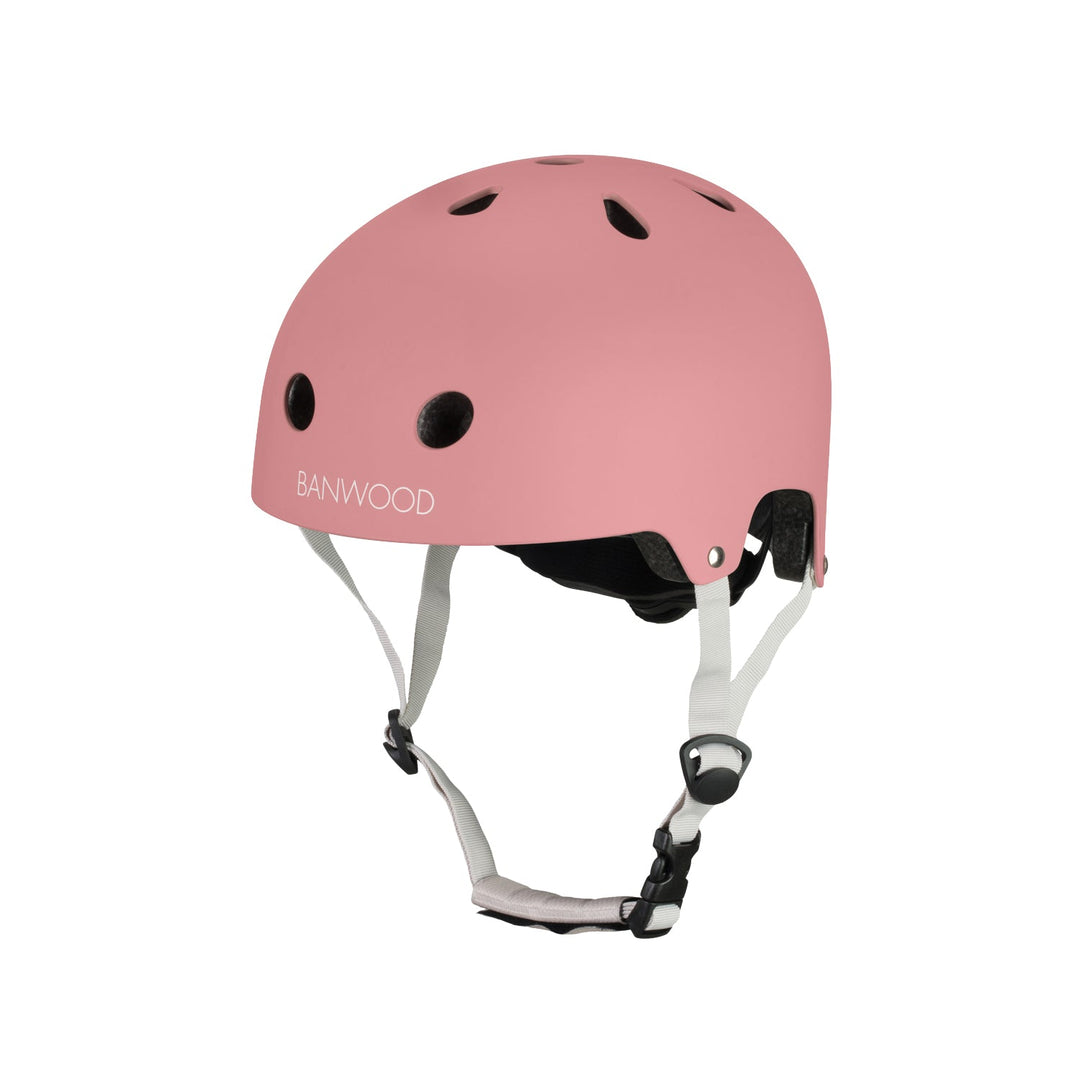 Pink Banwood helmet three-quarter view with ventilation holes and grey chin strap