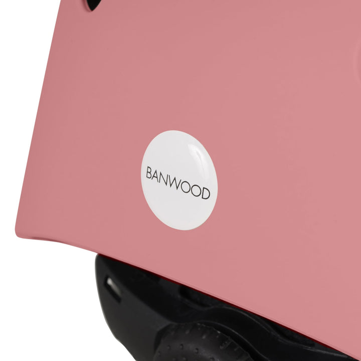 Close-up of pink Banwood helmet side showing white logo badge and black lining