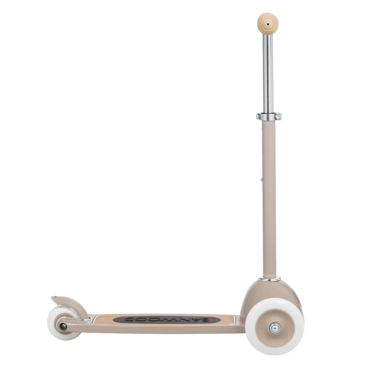Close-up of front wheel with white tyre, metal brake detail, and oak deck
