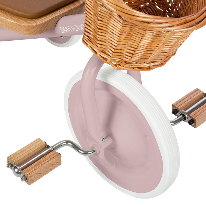 Close-up of oak wooden pedals with metal hardware and pink frame, Banwood