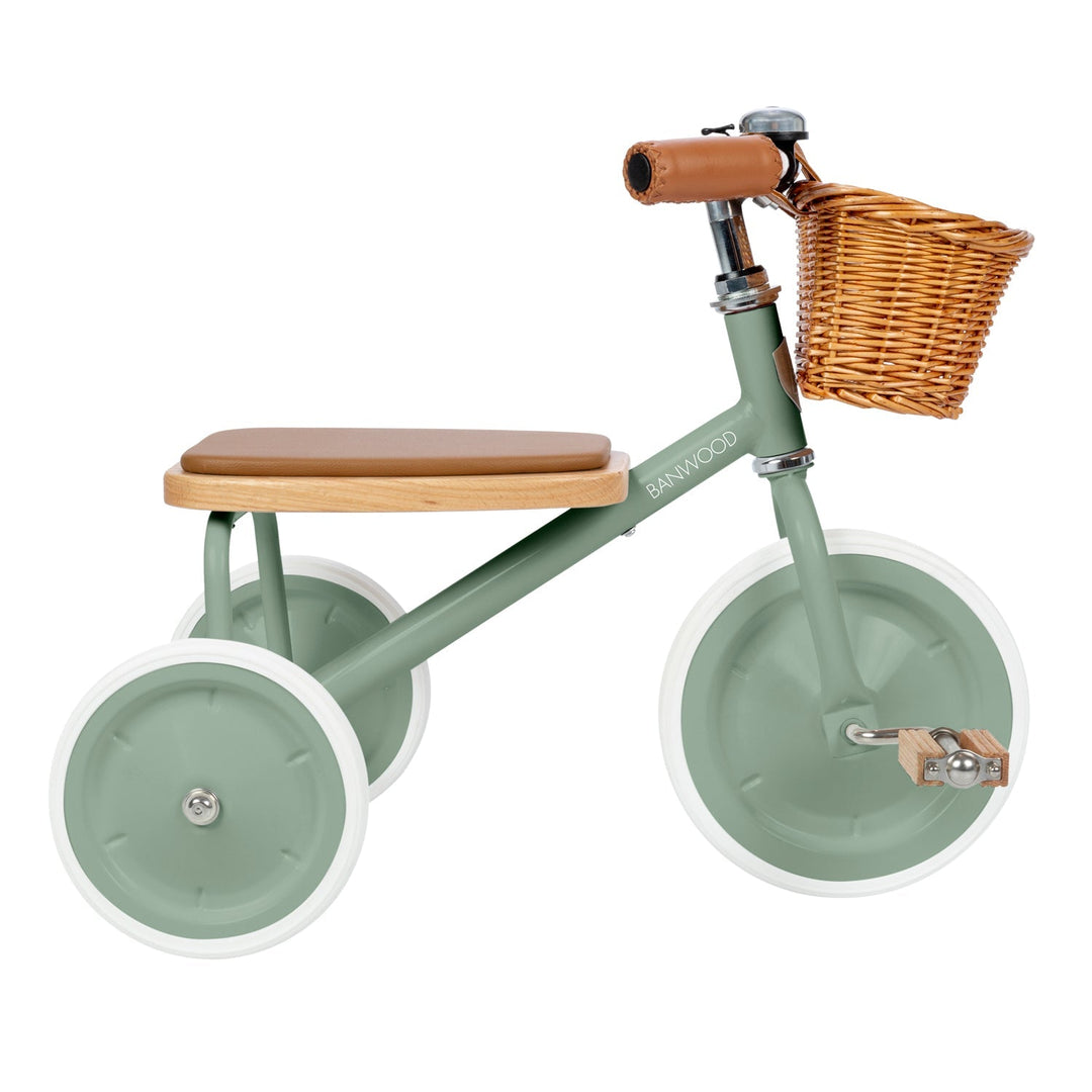 Sage green trike with wicker basket, brown leather grip and white-rimmed wheels, three-quarter view
