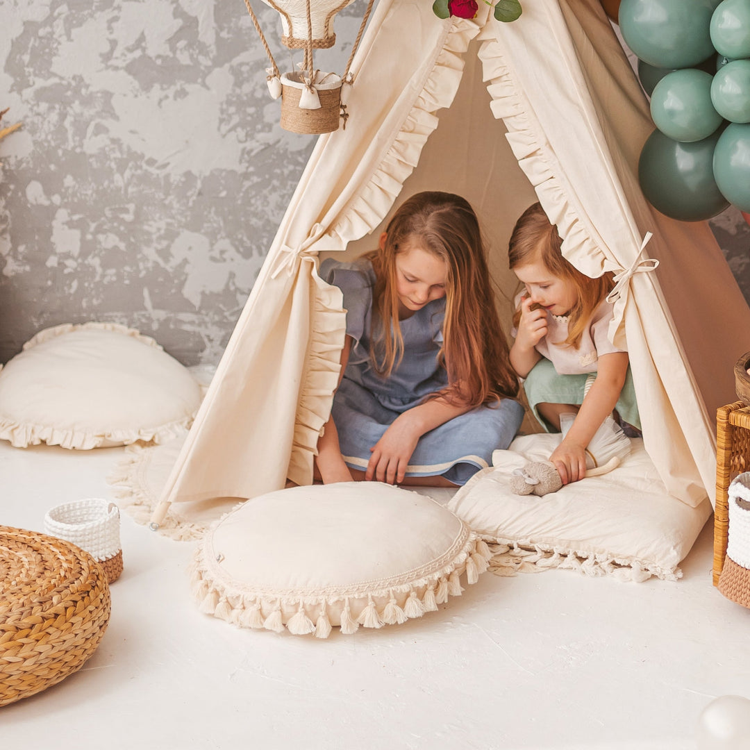 Children sitting in a play teepee with the MINICAMP Round Tassel Cushion