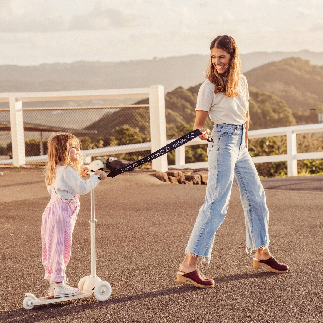 Woman holding black carry strap attached to child&