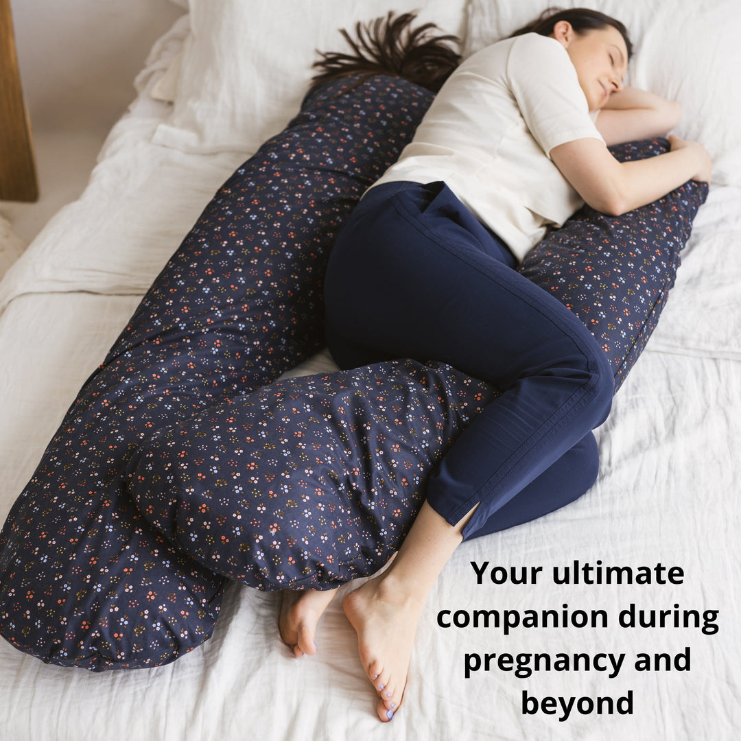 Woman sleeping using the MINICAMP U-shaped comfort pillow in navy blue