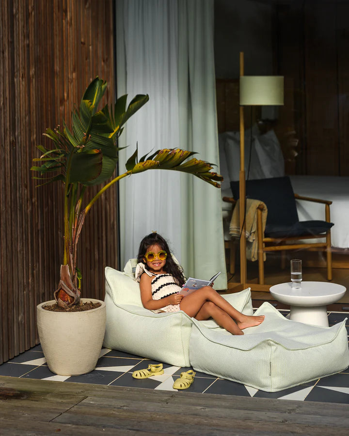 Cream beanbag chair with bird of paradise plant and coastal modern interior styling