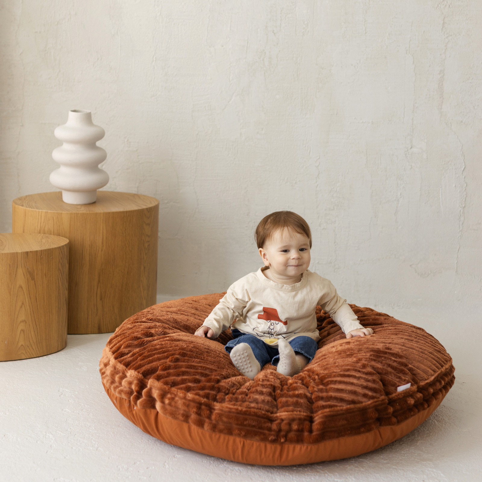 Baby sitting inside the MINICAMP terracotta corduroy floor cushion