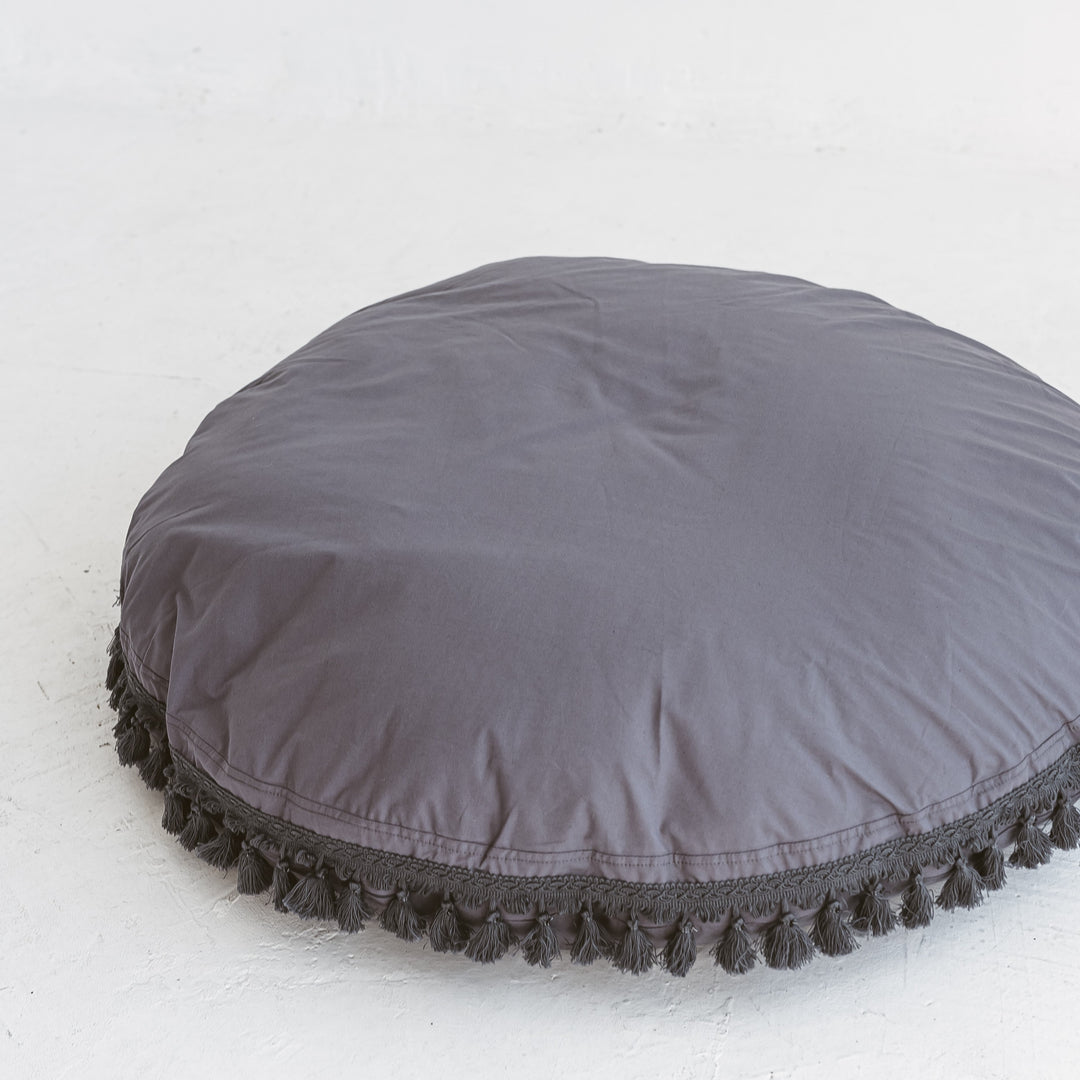 Close-up of the tasselled edge trim on the MINICAMP grey floor cushion