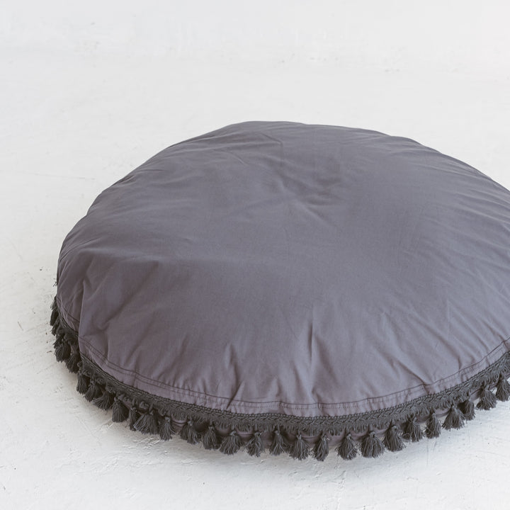Close-up of the tasselled edge trim on the MINICAMP grey floor cushion