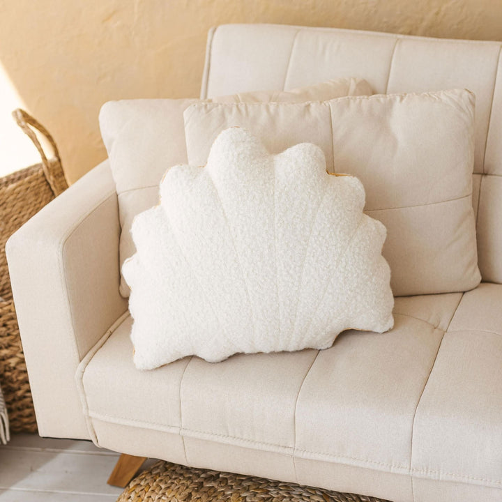 Ecru bouclé seashell cushion styled on a beige sofa