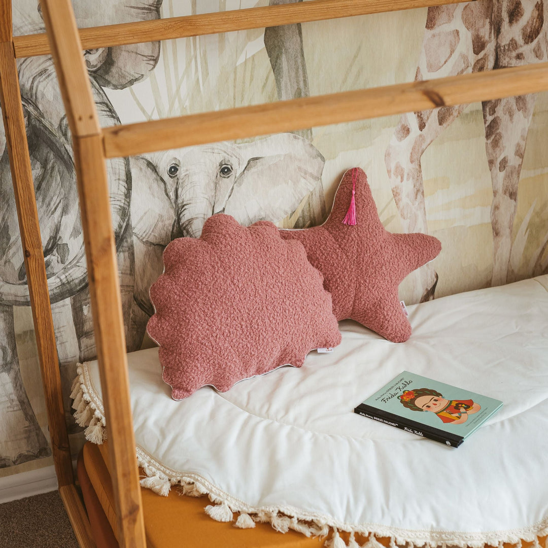 Rose bouclé seashell and starfish cushions styled together on a bed