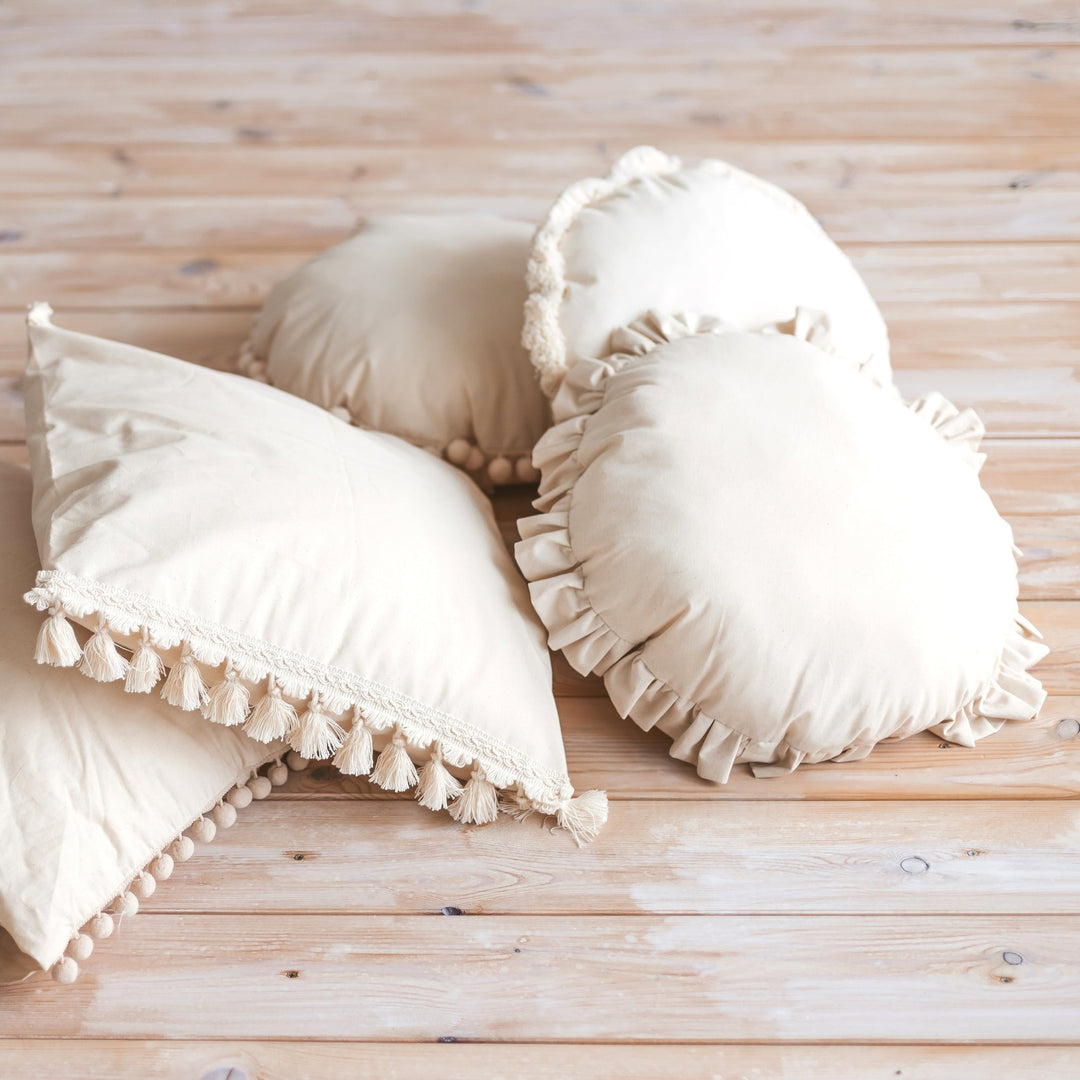 MINICAMP round cushions including the Ecru Pompom Trim Throw Pillow, styled together