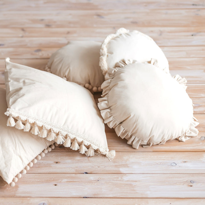 MINICAMP round cushions including the Ecru Pompom Trim Throw Pillow, styled together