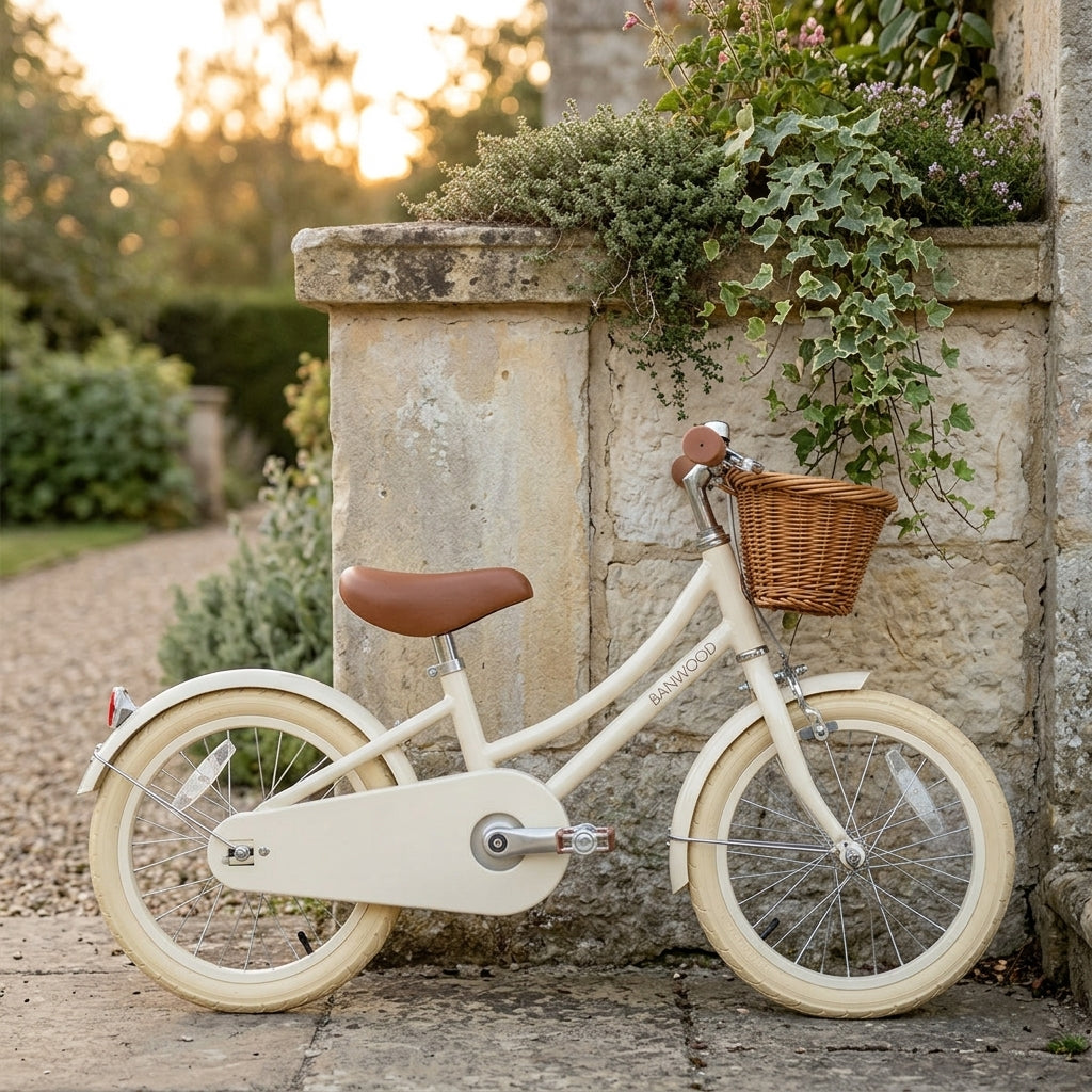 Cream Banwood Classic Bicycle styled against a stone garden wall showing its vintage Scandinavian design