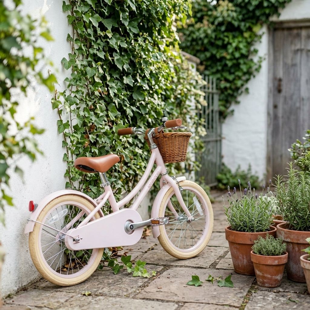 Pink Banwood Classic Bicycle styled against a garden wall showing its vintage Scandinavian design