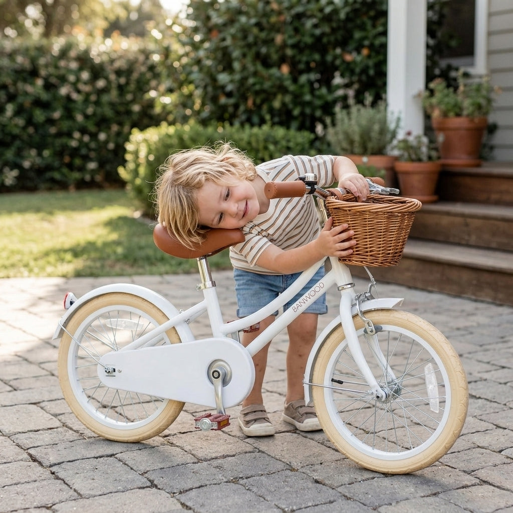 Child with the white Banwood Classic Bicycle on a home driveway