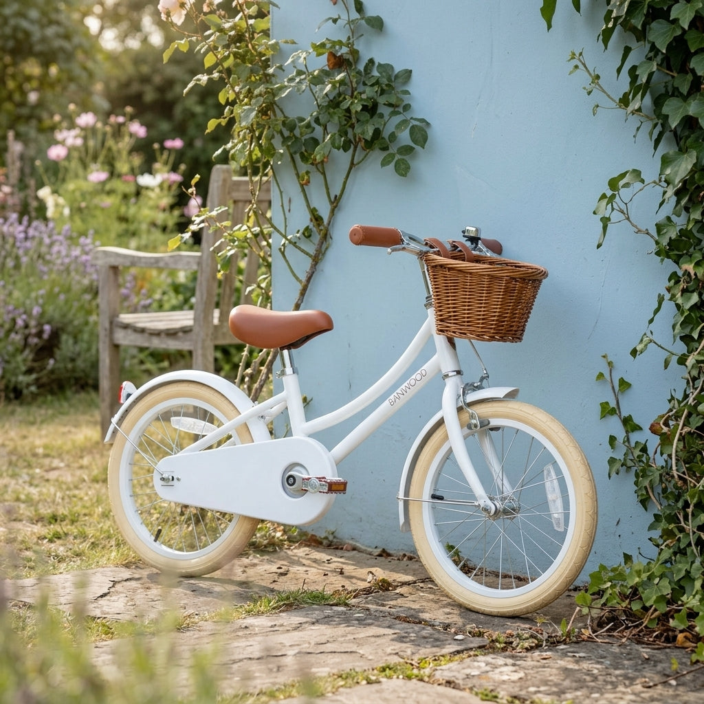 White Banwood Classic Bicycle styled against a pastel garden wall showing its vintage Scandinavian design