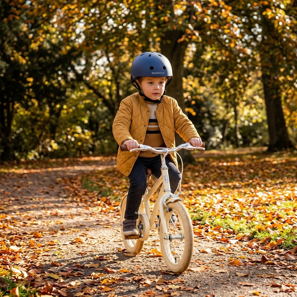 Child cycling outdoors in autumn wearing the Banwood Classic Helmet in matte navy