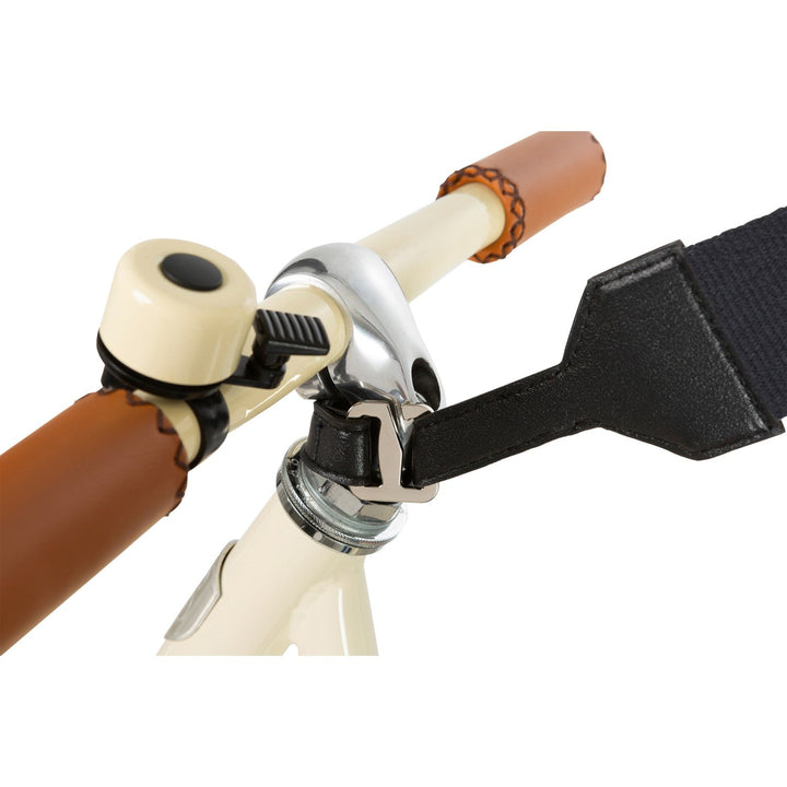 Cream balance bike handlebar with black carry strap and wooden grip detail