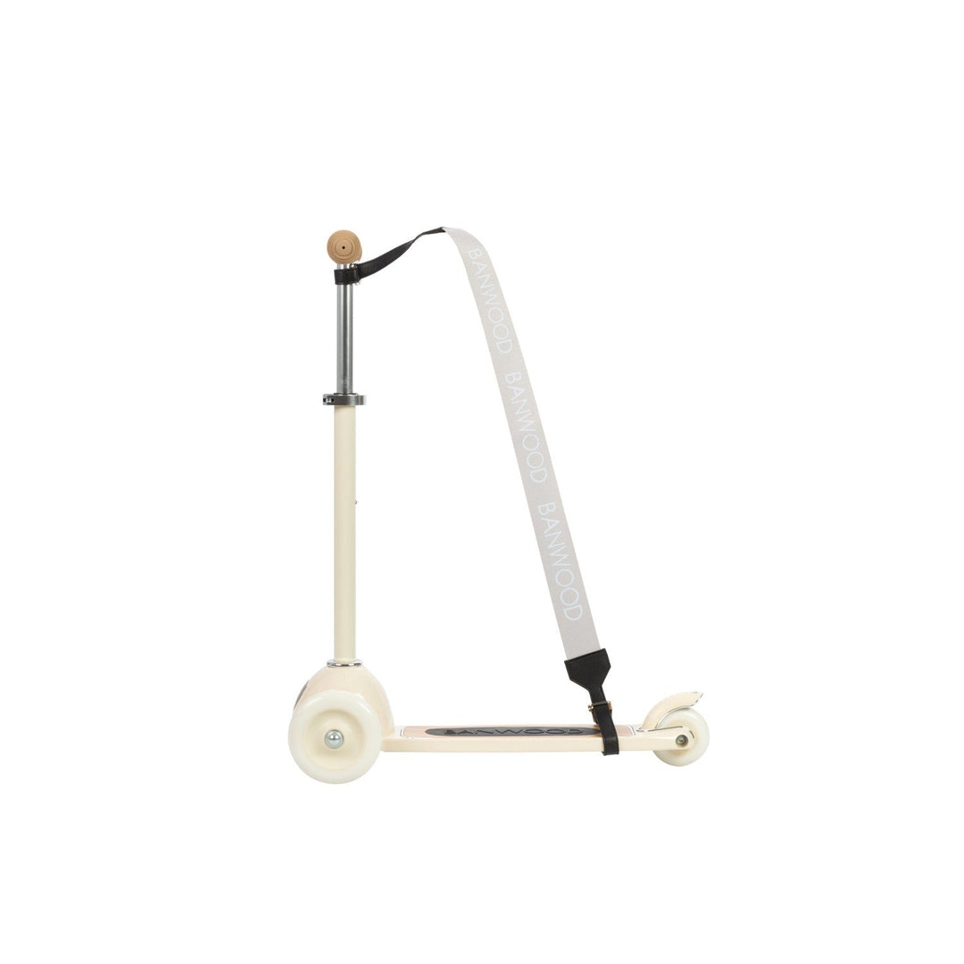 Cream scooter with black grip tape and carry strap looped over steering stem