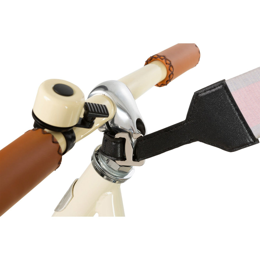 Bike handlebar detail with pink strap buckle and bell attachment