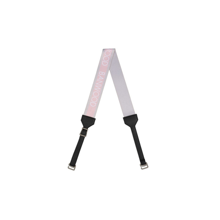 Pink striped carry strap with black pads and metal buckles, flat lay