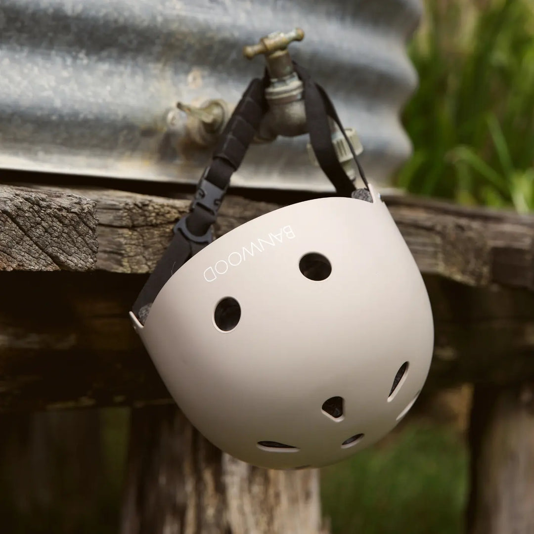 Beige helmet side profile hung on outdoor wooden fence detail Banwood