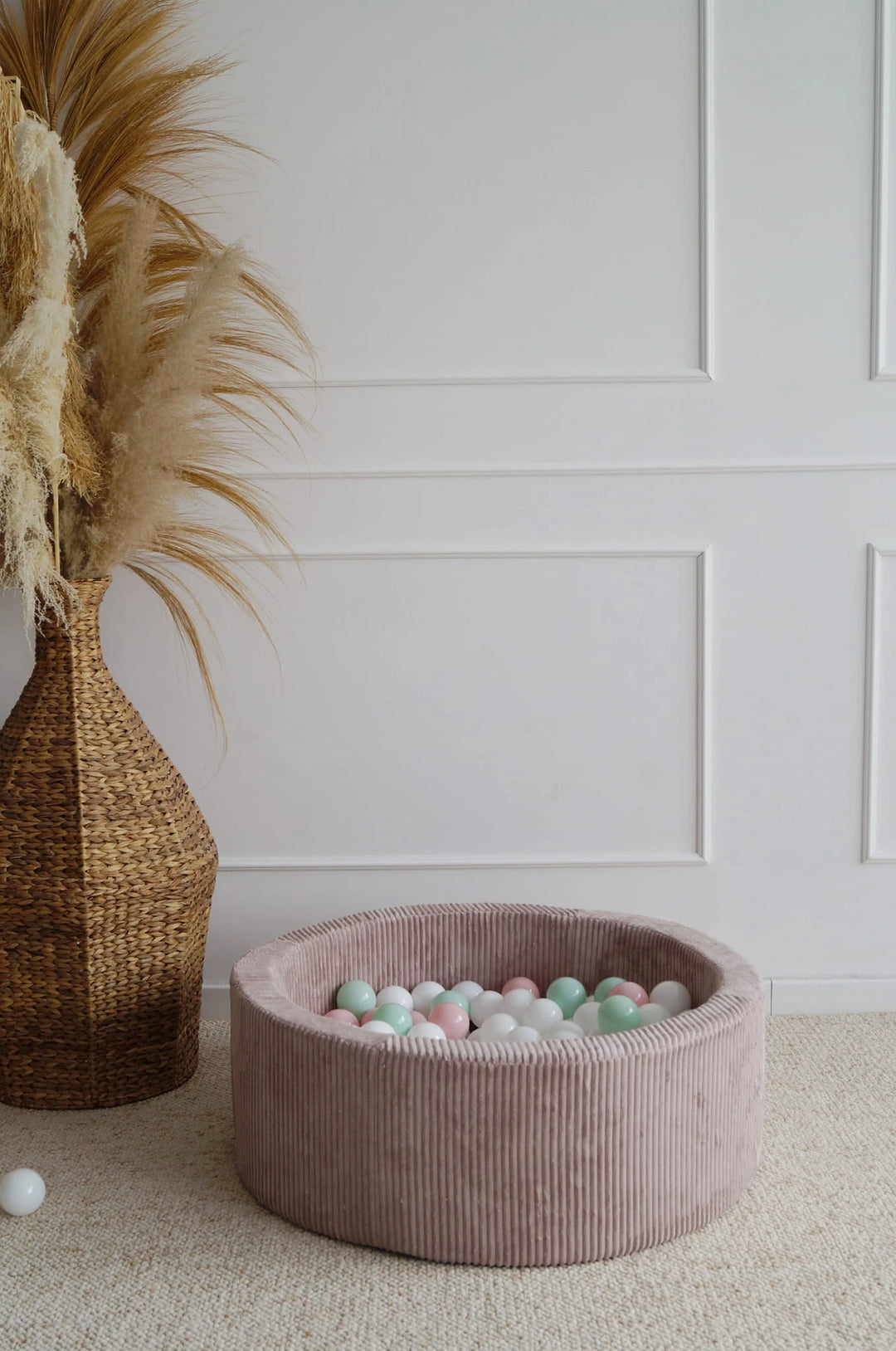 Monio for Kids Dirty Pink Corduroy Round Ball Pit — lifestyle image in warm-toned nursery