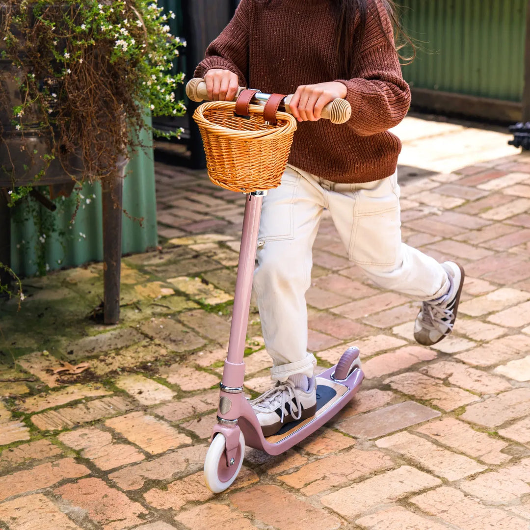 Child riding Banwood Maxi Scooter on garden patio, lifestyle action shot
