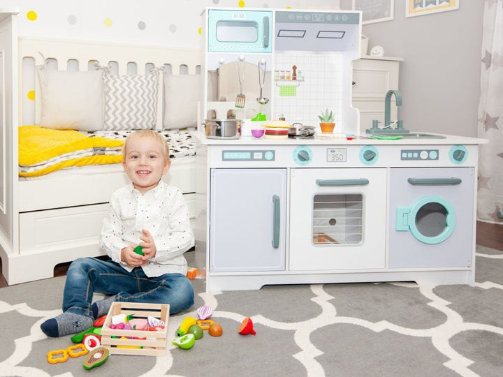 A child playing with the MeowBaby Grey &amp; Teal Wooden Play Kitchen and pretend food props (props not included)