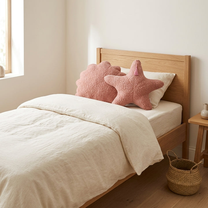 MINICAMP rose bouclé seashell and starfish cushions at the head of a child&