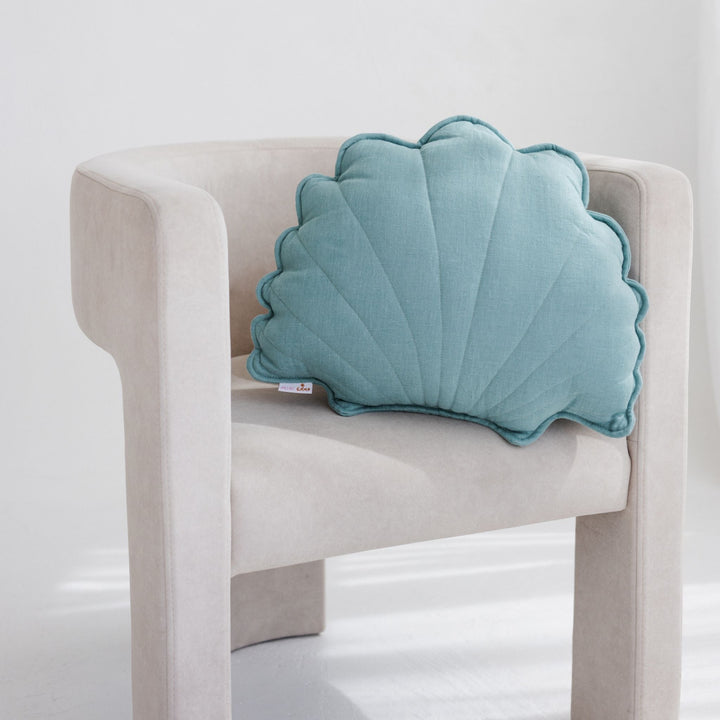 Mint linen seashell cushion styled on a cream armchair