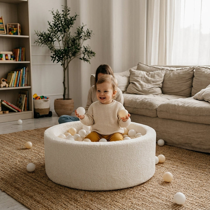 Toddler playing inside the Monio for Kids Ecru Plush Round Ball Pit at home