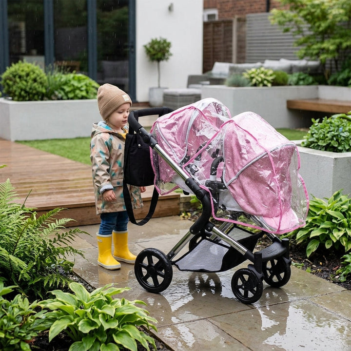 Twin Roma dolls pram with two clear PVC rain covers fitted, one over each seat unit, in a garden on a rainy day