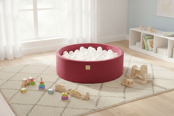 MeowBaby Raspberry Red Round Velvet Ball Pit on a rug in a bright playroom